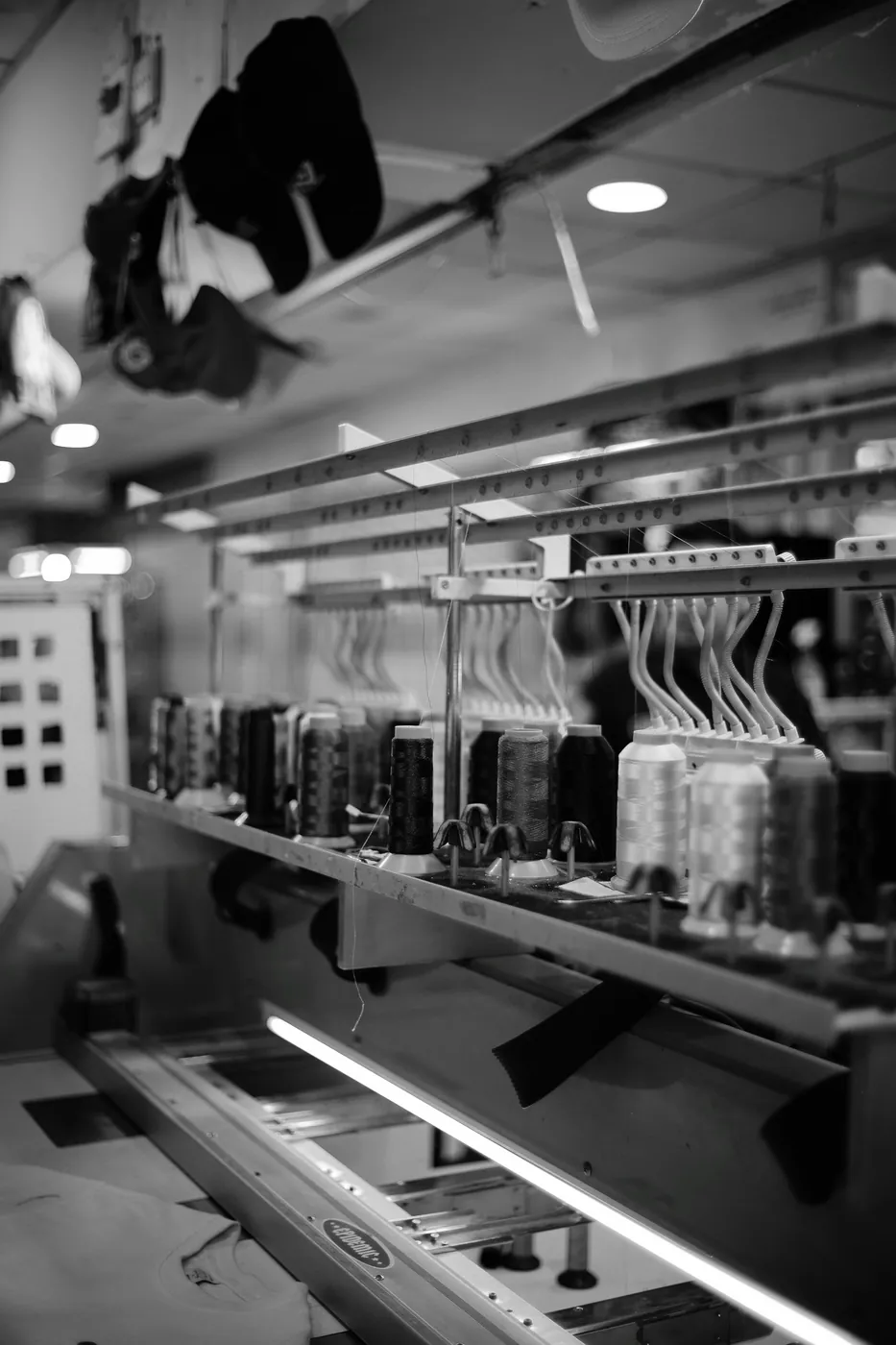 Máquina industrial y bobinas de hilo para el proceso de bordado.