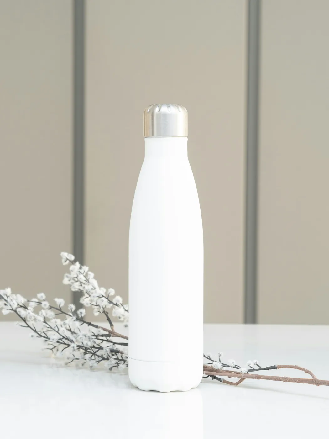 Botella blanca con tapa metálica como referencia de artículo personalizable.